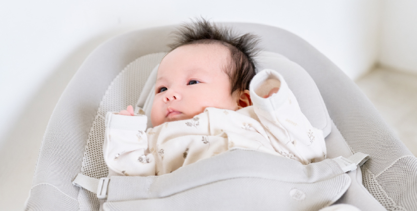 バウンサーに乗って落ち着いて過ごす赤ちゃん